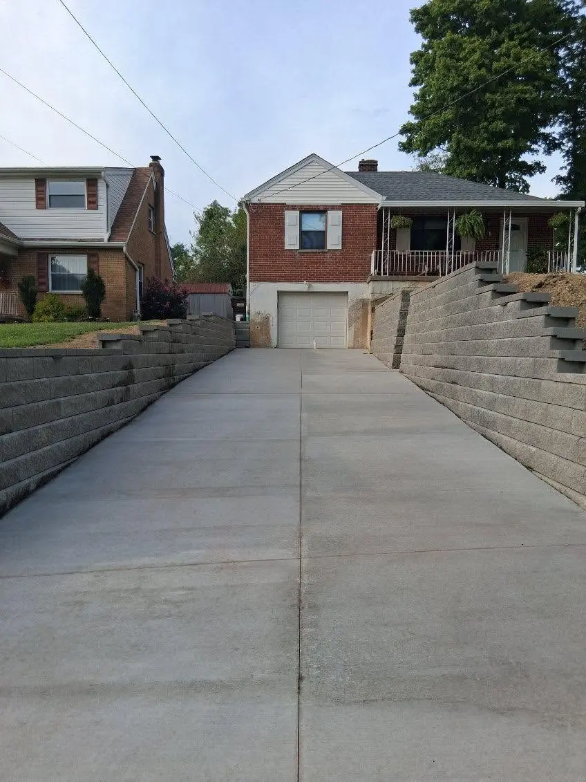 New concrete driveway running up to the garage in Cincinnati, OH between block retaining walls on both sides