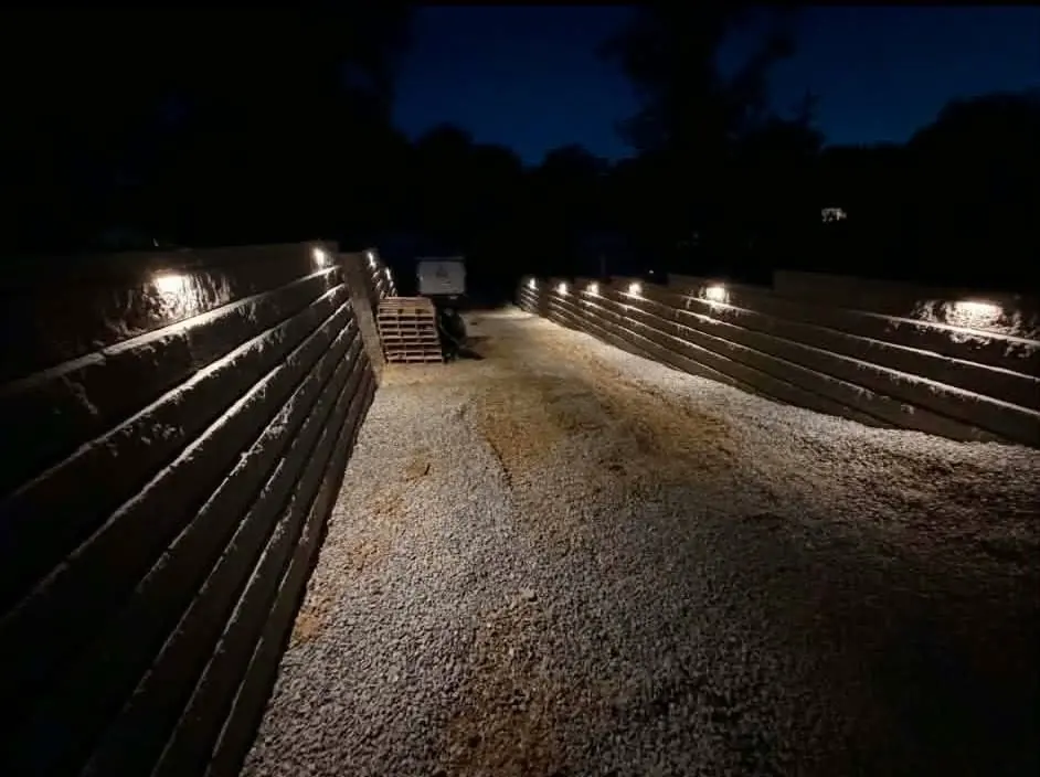 Both block retaining walls built and lit at night in Cincinnati, OH, driveway still on its gravel base