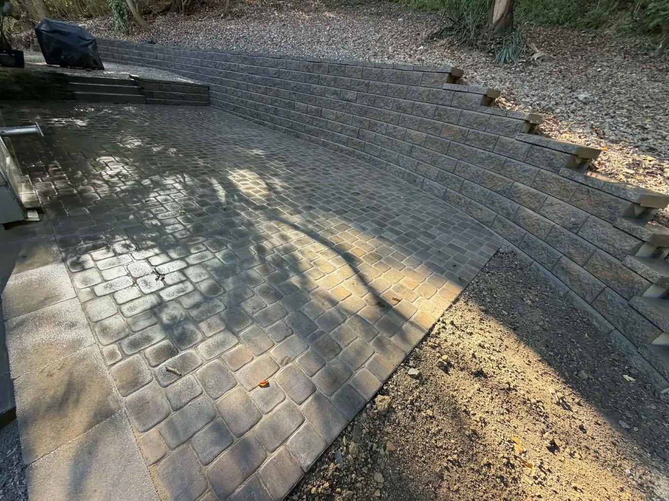 Paver patio running the length of the curved retaining wall behind the house in Cincinnati, OH