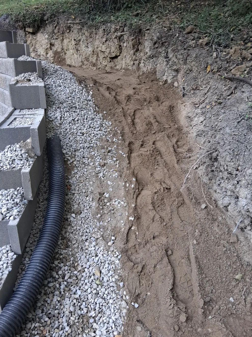 Drainage pipe and washed stone backfill behind the curved block wall in Cincinnati, OH