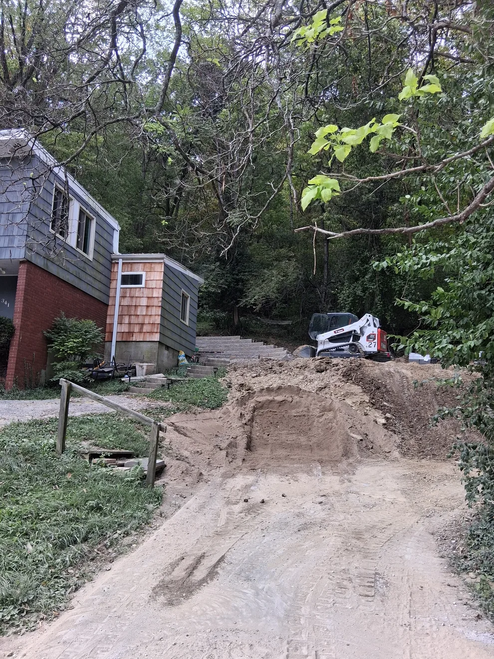 Dirt access ramp and skid steer beside the house in Cincinnati, OH, early in the dig