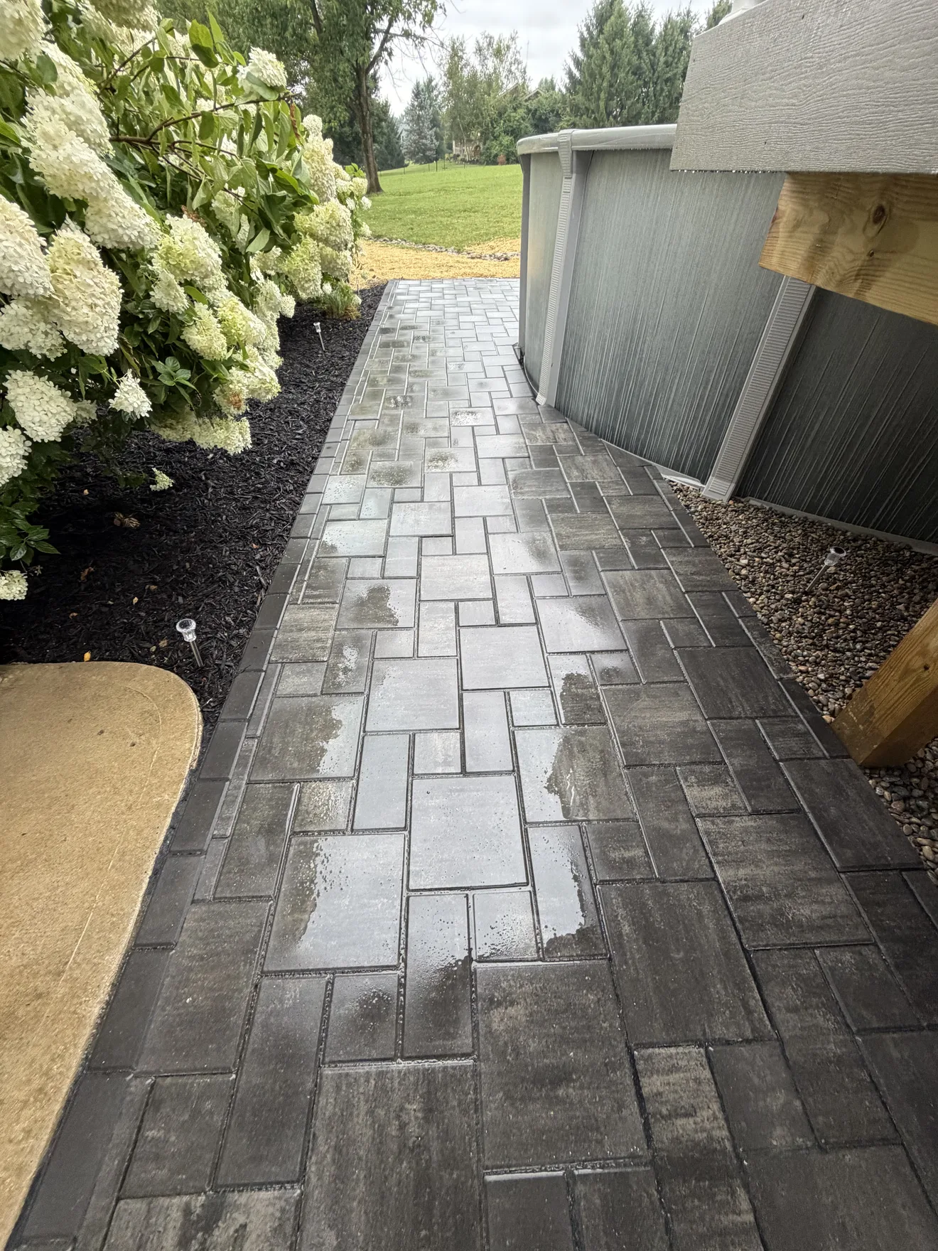 Paver walkway edged with charcoal border between the planting bed and the pool in Lebanon, OH