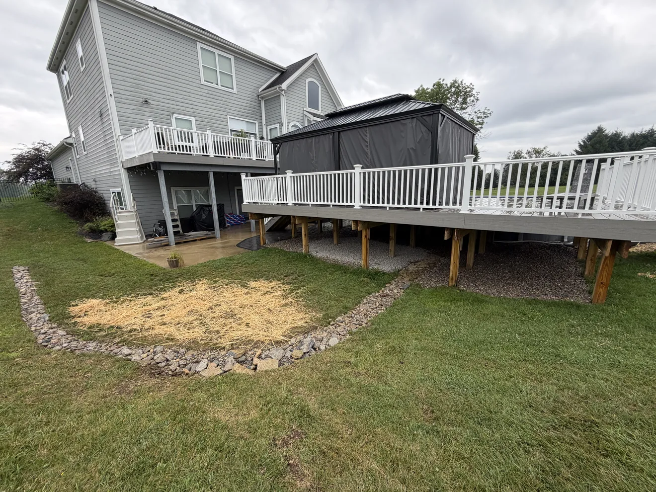 Rock lined drainage swale routing water out past the deck in Lebanon, OH