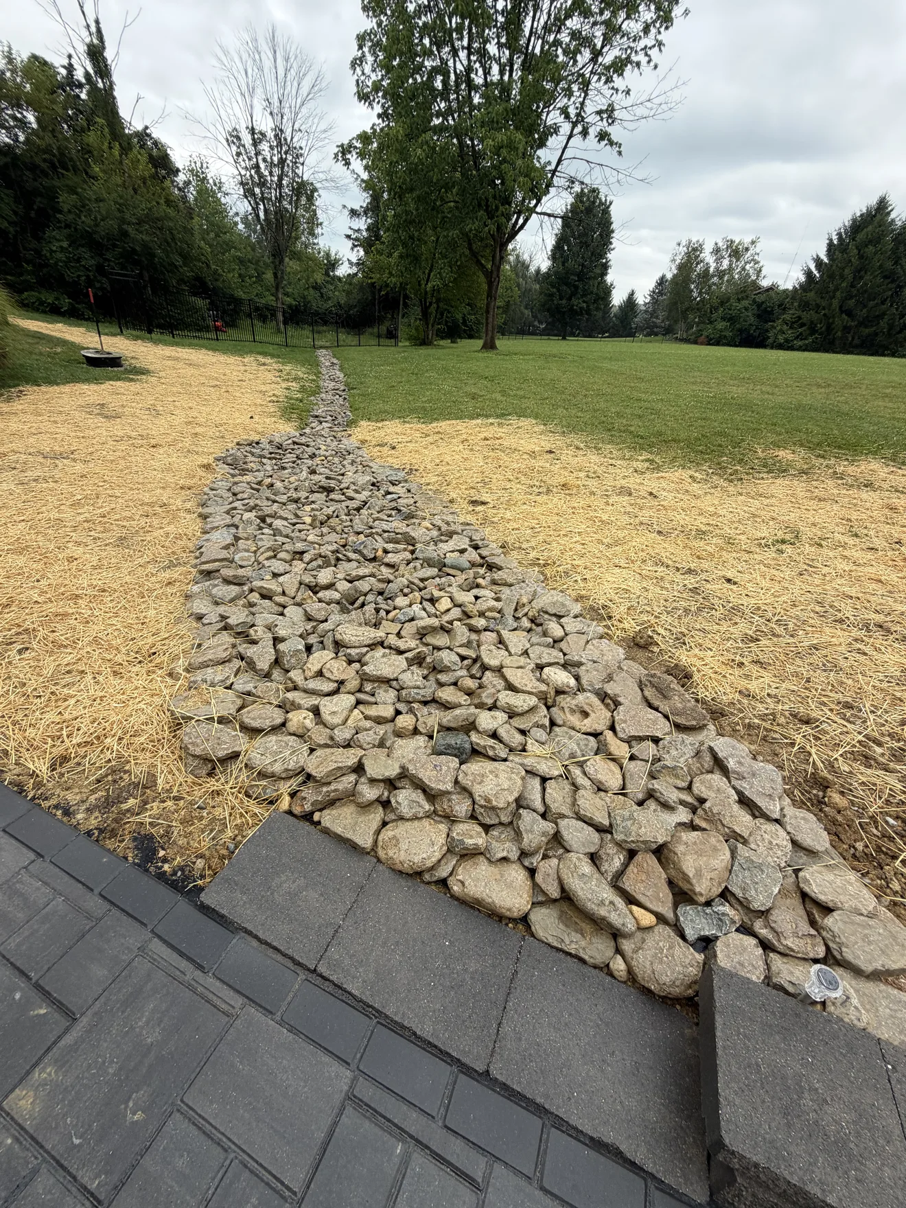 Stone rainscape channel carrying water away from the pool patio in Lebanon, OH